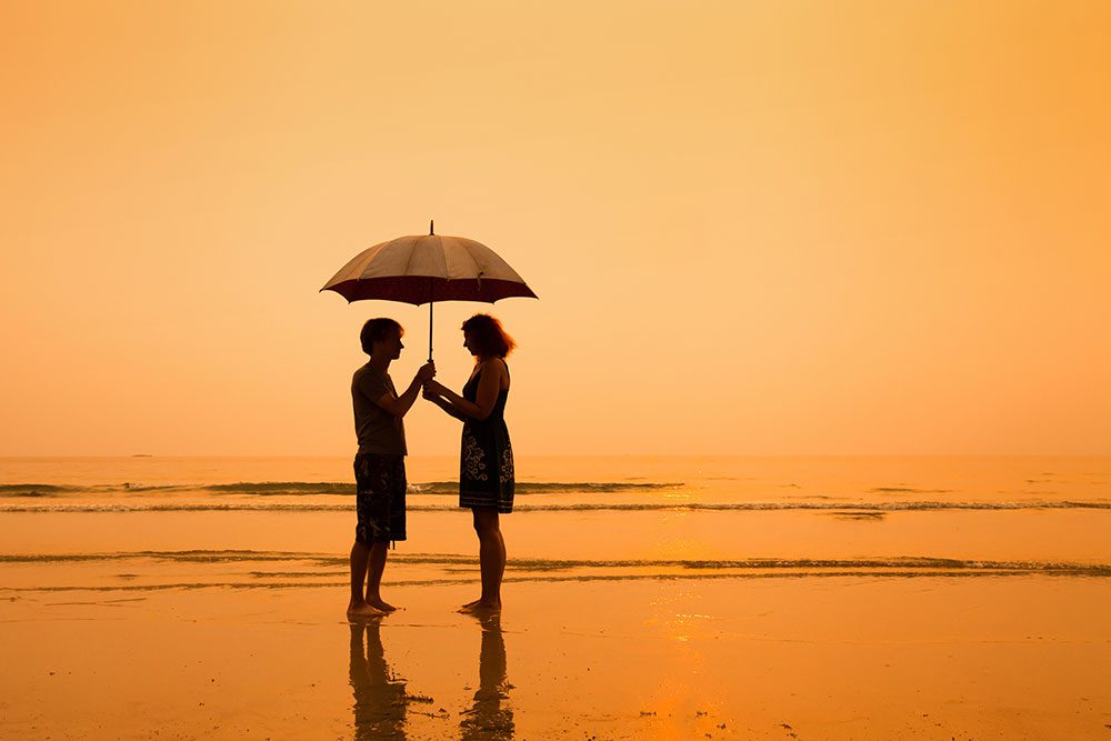 a couple on the beach at sunset under an umbrella - enabling behavior and codependency - Fair Oaks Recovery Center of california - sacramento drug addiction treatment center