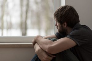 what is dual diagnosis? - depressed man looking out window