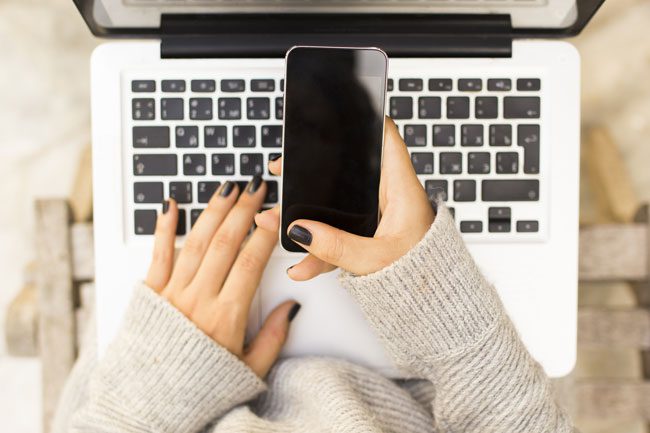 close up girl using phone and laptop