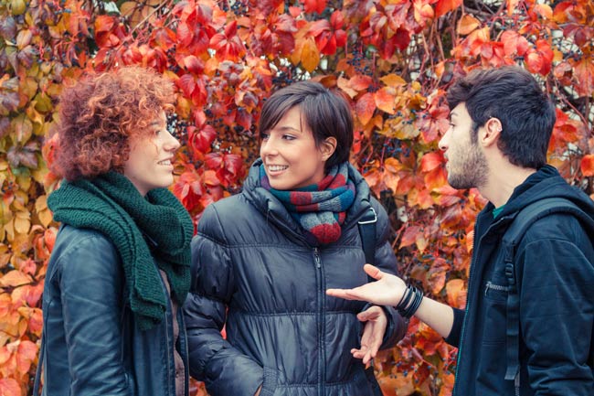 three people talking outdoors