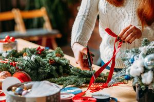 woman cutting ribbon for wreath - holiday season