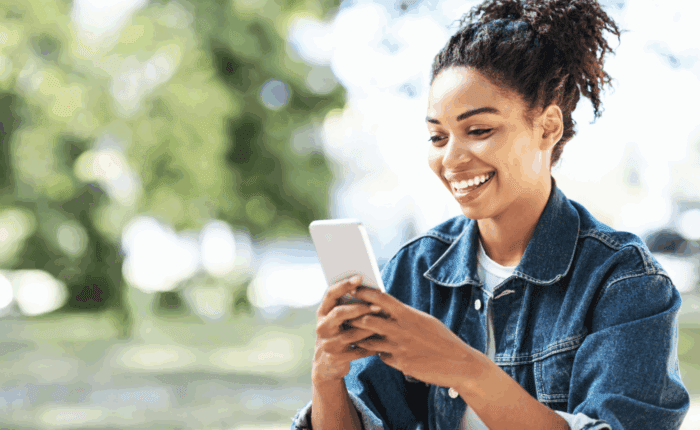 A smiling woman using her phone.