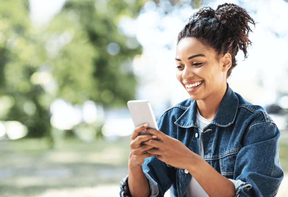 A smiling woman using her phone.