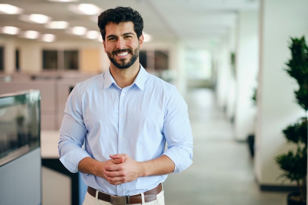 Fair Oaks - Trust Fair Oaks to Provide Discreet Treatment for Professionals. A young professional stands in a office setting smiling.